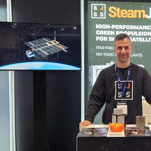 Steamjet Space Systems exhibiting at a space conference in March 2026 with a TV screen which is displaying their satellite animation produced by Sound Motive.